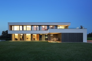 Wie ein leuchtender Edelstein funkelt das transparent konzipierte Haus in der blauen Stunde. Wie ein leuchtender Edelstein funkelt das transparent konzipierte Haus in der blauen Stunde.